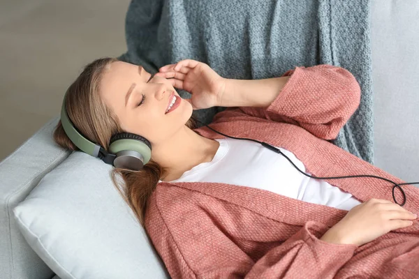 Beautiful young woman listening to music at home — Stock Photo, Image