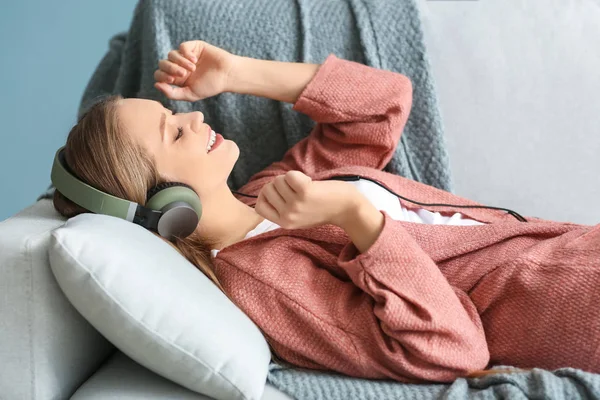 Beautiful young woman listening to music at home — Stock Photo, Image