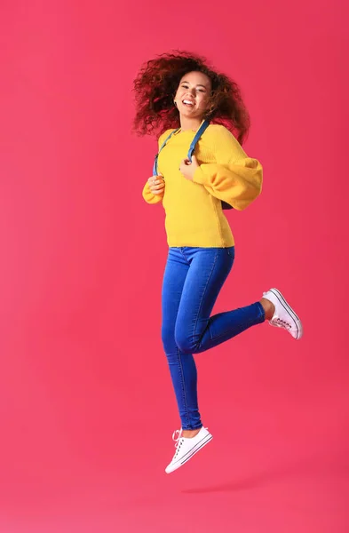 Jumping young woman on color background — Stock Photo, Image