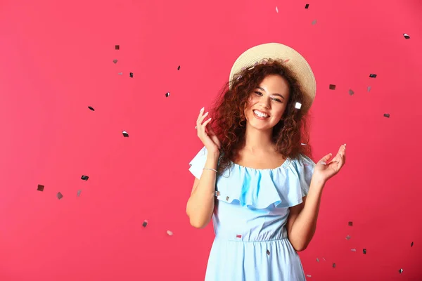 Щаслива молода жінка з конфетті на кольоровому фоні — стокове фото