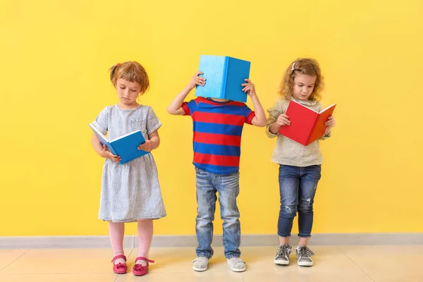 Niedliche kleine Kinder lesen Bücher in der Nähe der Farbwand — Stockfoto