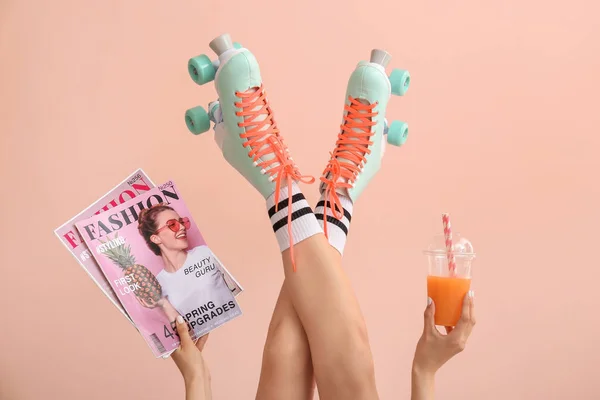 Woman in vintage roller skates, with fashion magazines and juice on color background — Stock Photo, Image