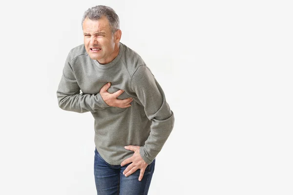 Зрілий чоловік, що страждає від серцевого нападу на білому тлі — стокове фото