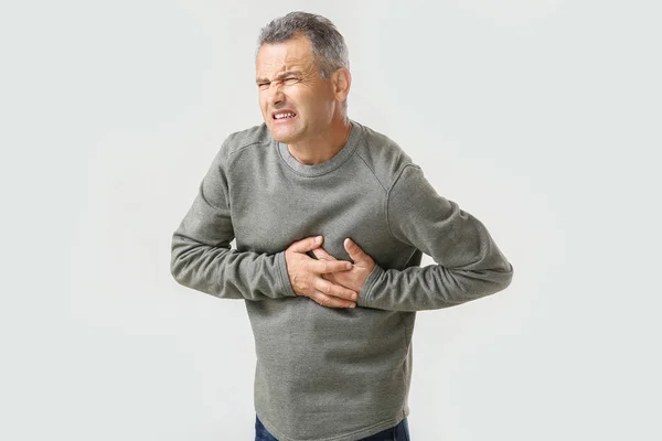 Homem maduro que sofre de ataque cardíaco no fundo branco — Fotografia de Stock