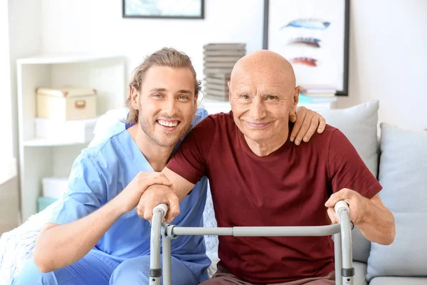 Elderly man with caregiver in nursing home — Stock Photo, Image