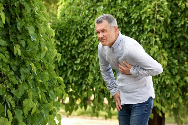 Volwassen man lijdt aan hartaanval buitenshuis — Stockfoto