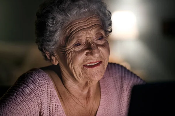 Mulher sênior usando laptop à noite — Fotografia de Stock