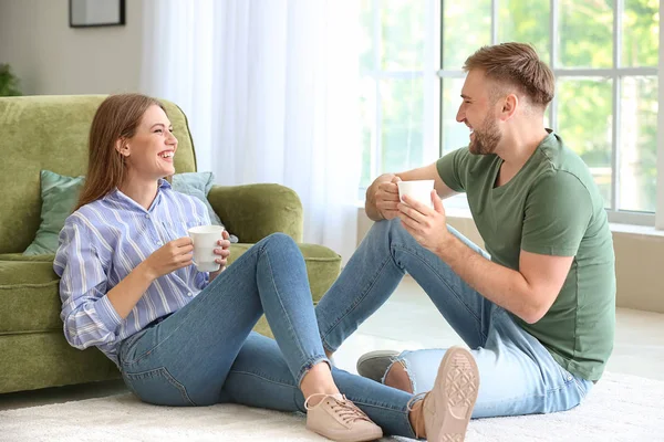 Портрет щасливої молодої пари, що п'є каву вдома — стокове фото