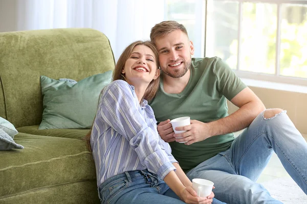 Retrato de pareja joven y feliz tomando café en casa — Foto de Stock