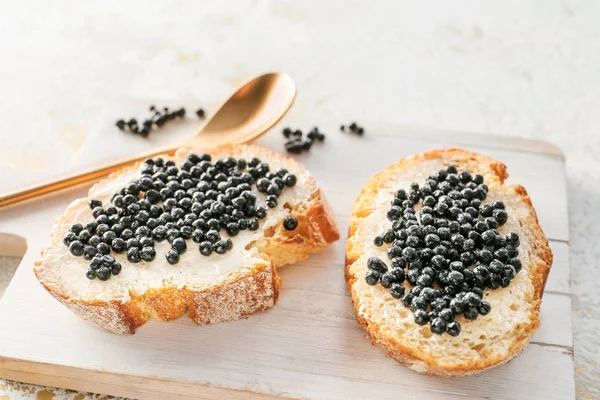 Sandwiches with black caviar on board — Stock Photo, Image