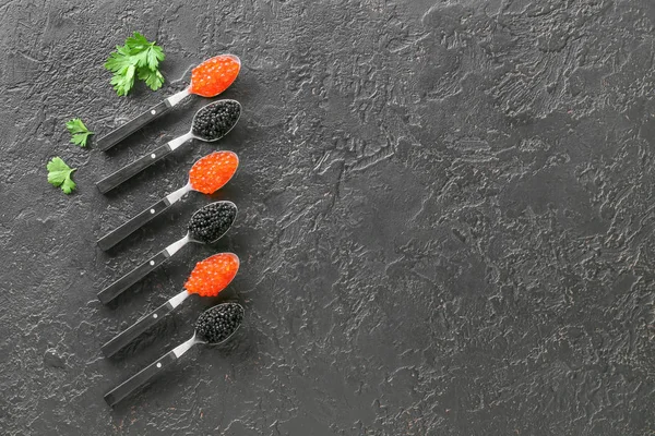 Spoons with delicious caviar on dark background — Stock Photo, Image