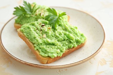 Hafif arka planda lezzetli avokado tost ile Plaka