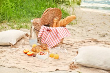 Nehir yakınında romantik piknik için lezzetli yiyecek ve içecek ile Wicker sepeti