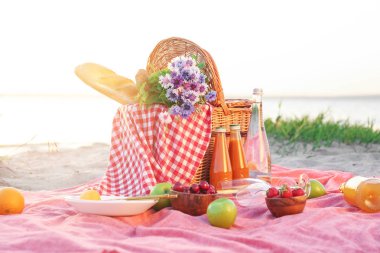 Nehir yakınında romantik piknik için lezzetli yiyecek ve içecek ile Wicker sepeti