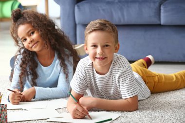 Mutlu evlatedinilmiş çocuklar yeni evlerinde resim çiziyor