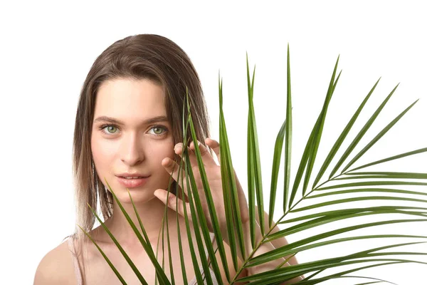 Beautiful young woman with tropical leaf on white background — Stock Photo, Image