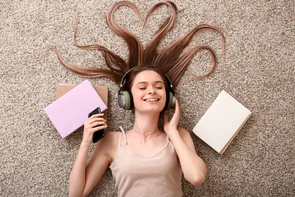 Beautiful young woman listening to audiobook at home — Stock Photo, Image