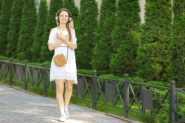 Schöne junge Frau hört Hörbuch im Park — Stockfoto