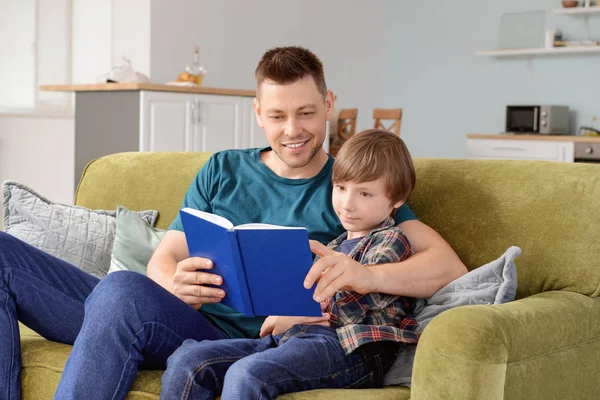 Vader en zijn kleine zoon lezen boek thuis — Stockfoto