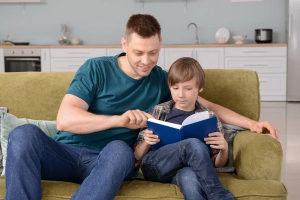 Far och hans lille son Läs bok hemma — Stockfoto