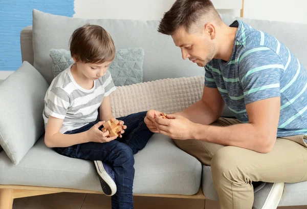 Father and son with brain teaser toys at home