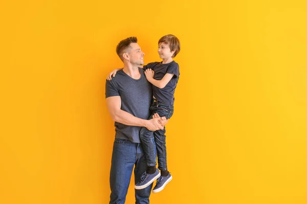 Portrait of father and son on color background — Stock Photo, Image