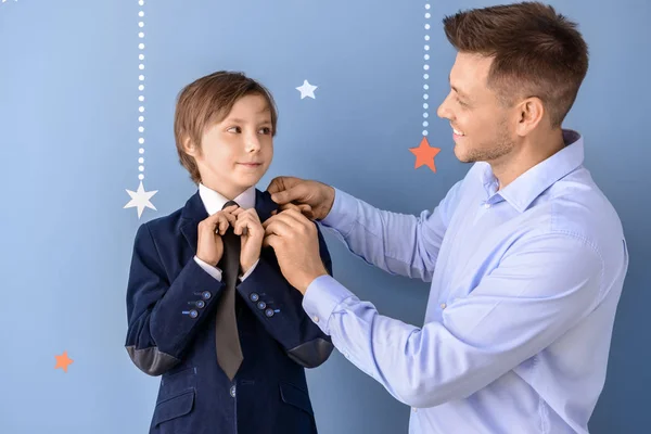 Elegante niño con su padre en el fondo de color — Foto de Stock