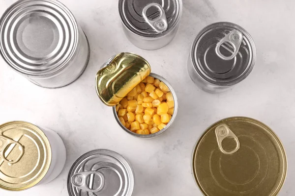 Latas de lata com comida no fundo claro — Fotografia de Stock