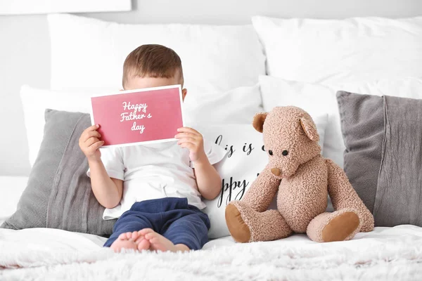 Aranyos kisfiú üdvözlőkártyával Apák napja ágyon — Stock Fotó