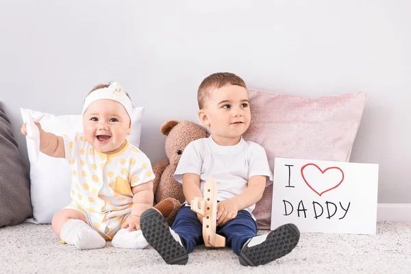 Cute little children with greeting card for Father's Day near light wall — Stock Photo, Image