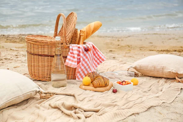 Cesta de mimbre con sabrosa comida y bebida para picnic romántico cerca del río — Foto de Stock