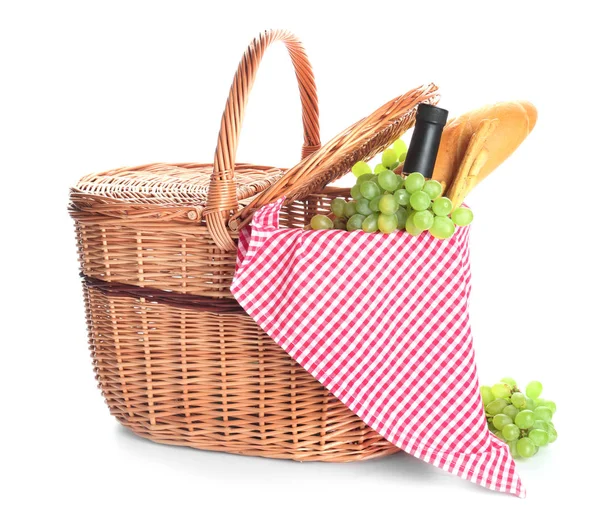 Wicker basket with tasty food and drink for picnic on white background — Stock Photo, Image