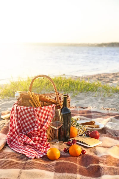 威克篮子，可享用美味的食物和饮料，适合在河边进行浪漫野餐 — 图库照片
