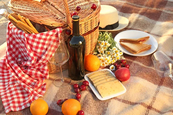 Wicker basket with tasty food and drink for romantic picnic outdoors — Stock Photo, Image