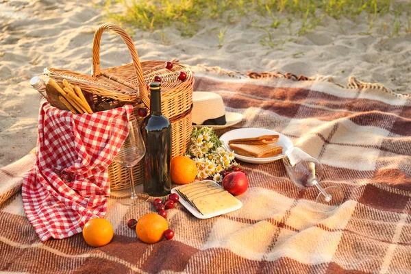 Cesto di vimini con cibi e bevande gustosi per un romantico picnic sulla spiaggia — Foto Stock