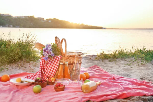 威克篮子，可享用美味的食物和饮料，适合在河边进行浪漫野餐 — 图库照片