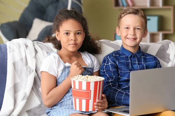 Счастливые приемные дети с ноутбуком смотрят мультики в своем новом доме — стоковое фото