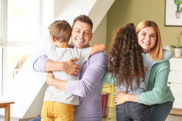 Pareja feliz con niños adoptivos en casa —  Fotos de Stock