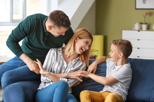 Glückliches Paar spielt mit kleinem Adoptivkind zu Hause — Stockfoto