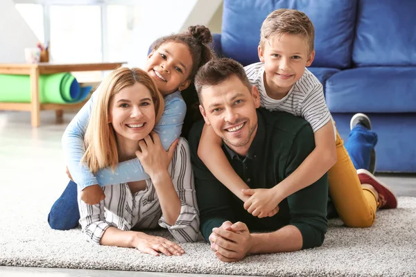 Pareja feliz con niños adoptivos en casa —  Fotos de Stock