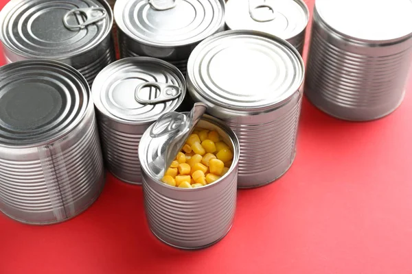 Latas de lata con comida sobre fondo de color — Foto de Stock
