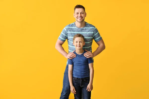 Homem feliz com menino adotado pouco no fundo de cor — Fotografia de Stock