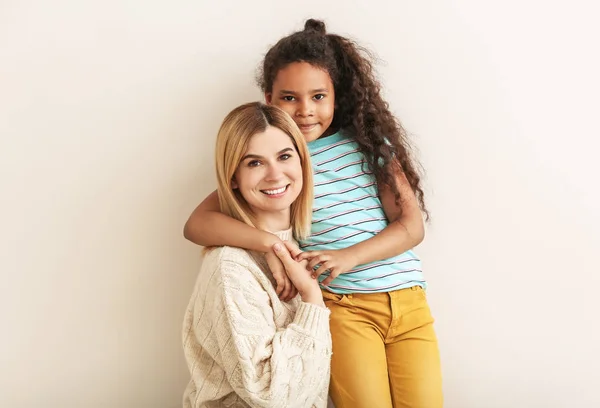 Happy woman with little adopted African-American girl on white background — Stock Photo, Image