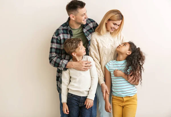 Šťastný pár s malými adoptovanými dětmi na bílém pozadí — Stock fotografie