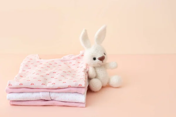 Pilha de roupas de bebê no fundo de cor — Fotografia de Stock
