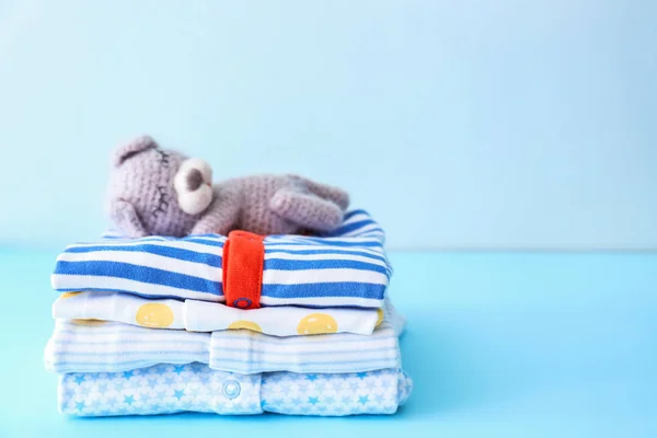 Stack of baby clothes on color background — Stock Photo, Image