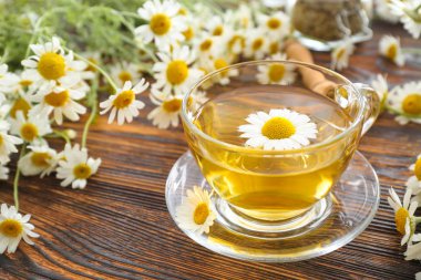 Ahşap masada sıcak papatya çayı Fincan