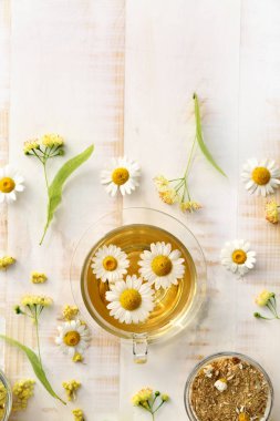 Hafif ahşap masa üzerinde sıcak papatya çayı ile Kompozisyon