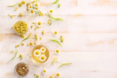 Hafif ahşap masa üzerinde sıcak papatya çayı ile Kompozisyon