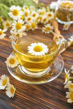 Ahşap masada sıcak papatya çayı Fincan